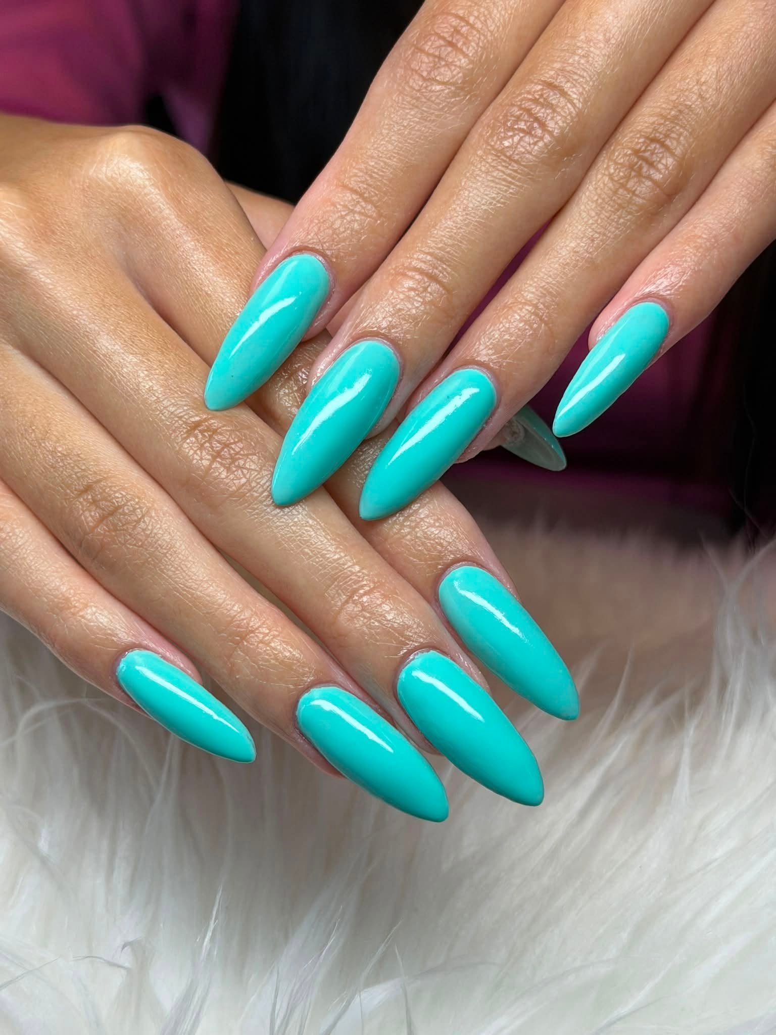 Long stiletto acrylic nails in solid turquoise