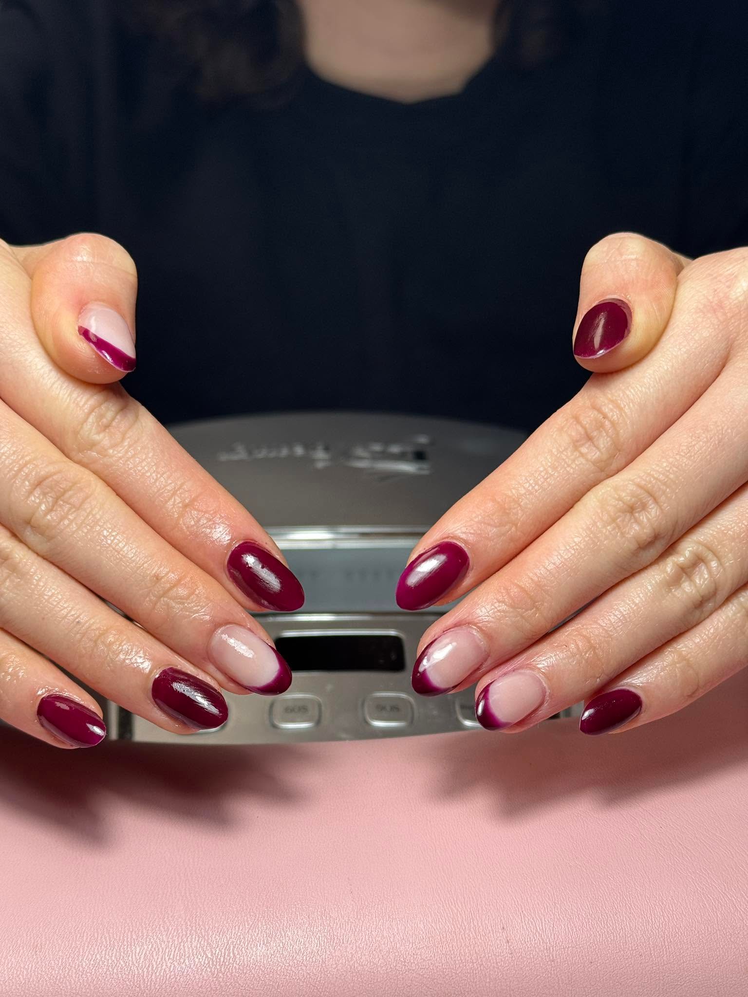 Deep burgundy solid gel manicure with sheer French accents on thumbs