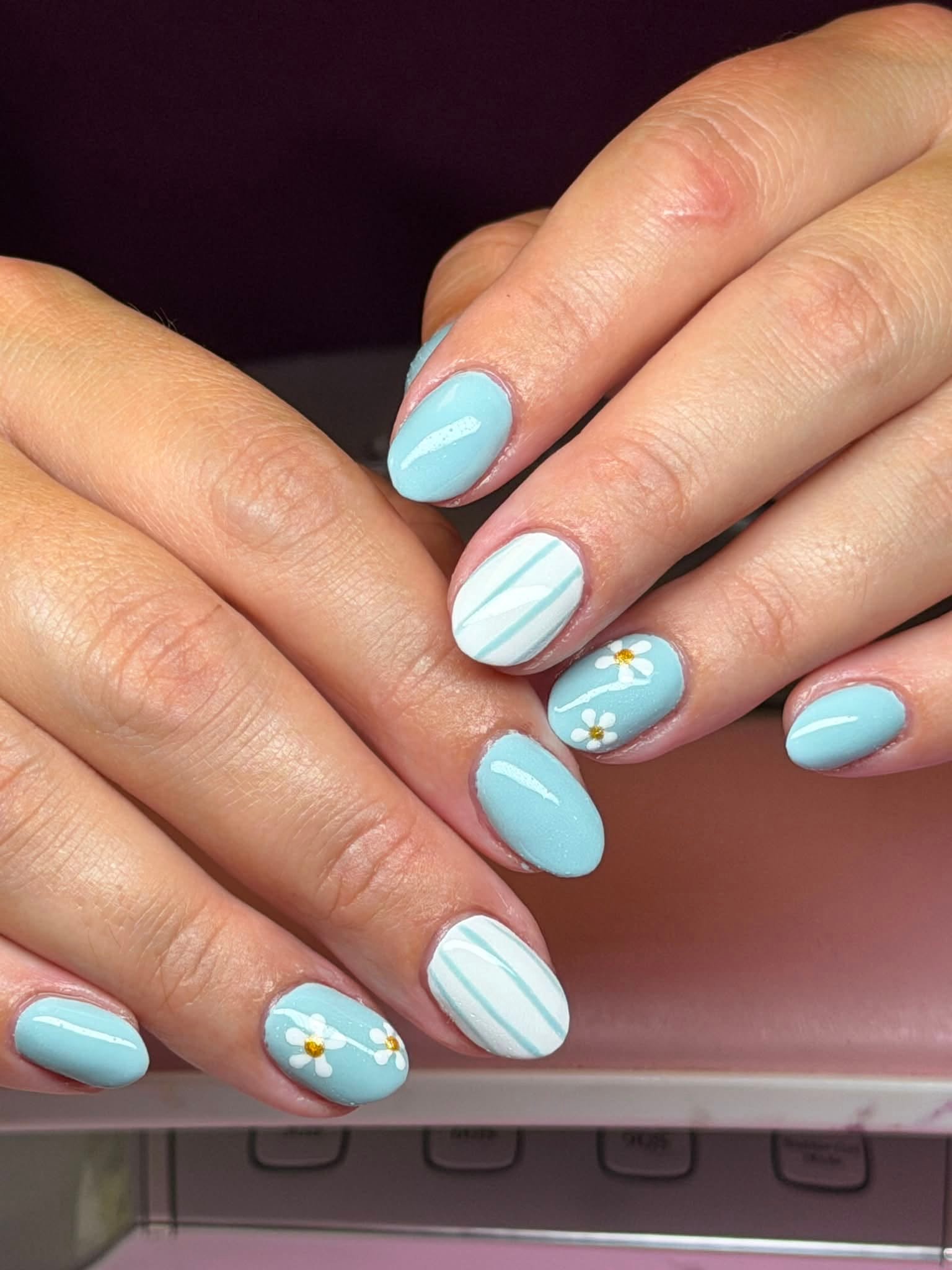 Sky blue nails with hand-painted daisies and stripes