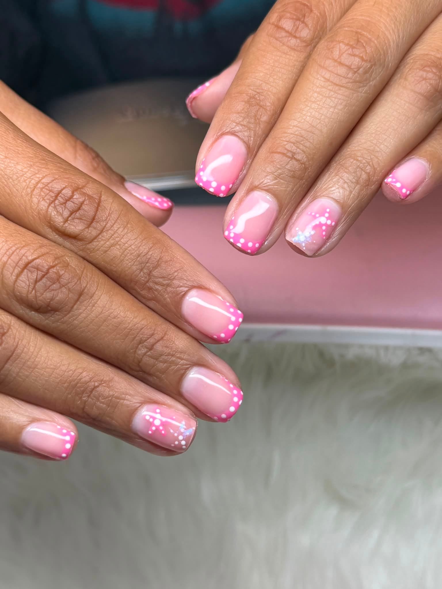 Pink nails with white polka dots and star accents