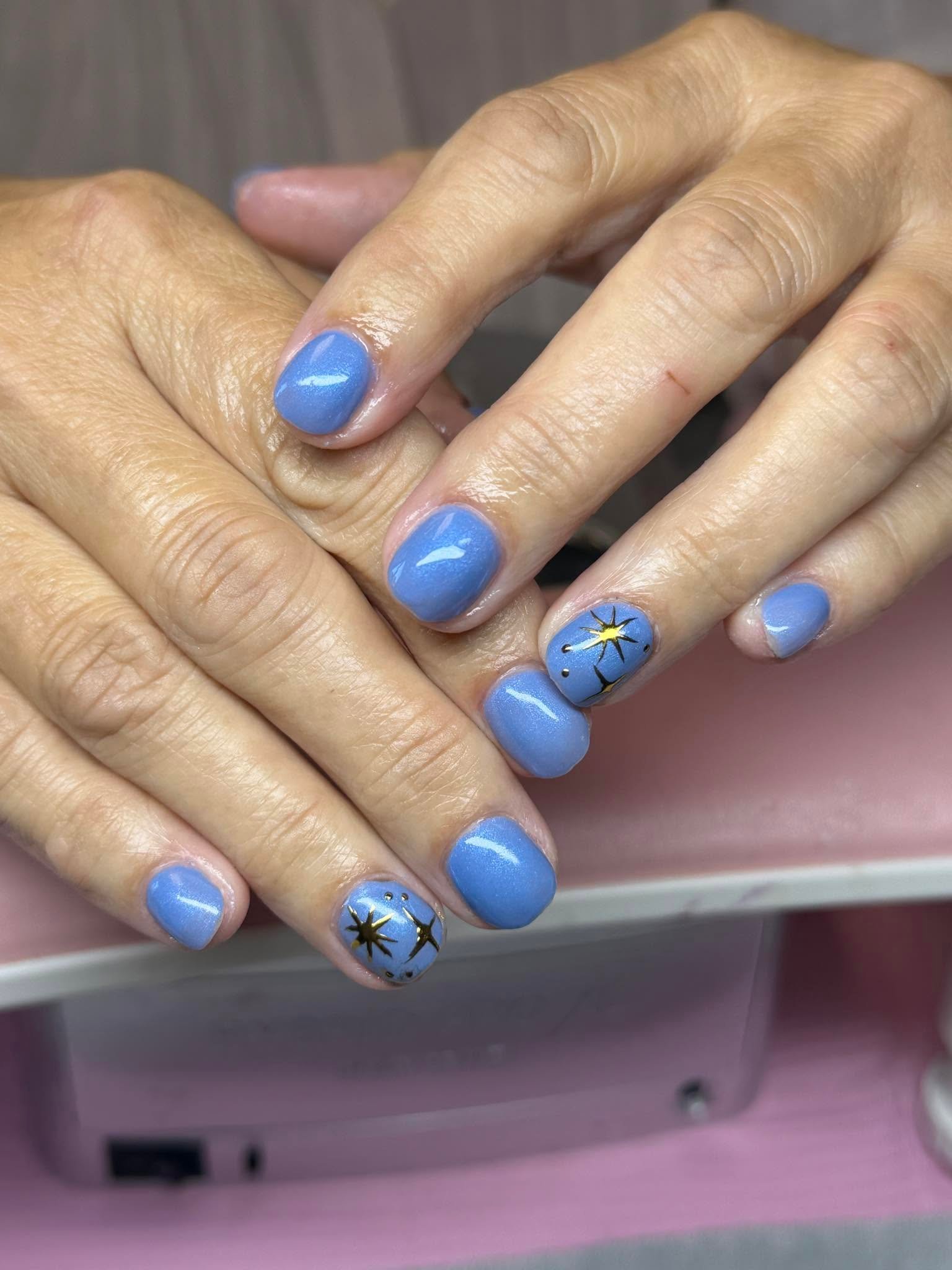 Periwinkle blue nails with a gold starburst accent nail