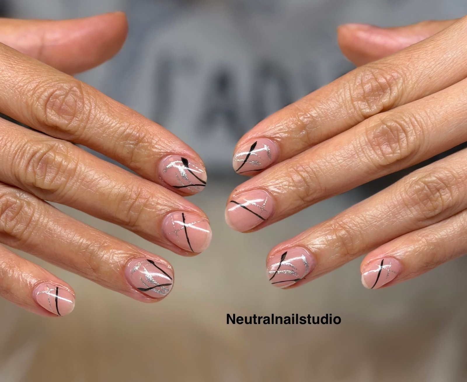 Nude nails with abstract black and silver line art