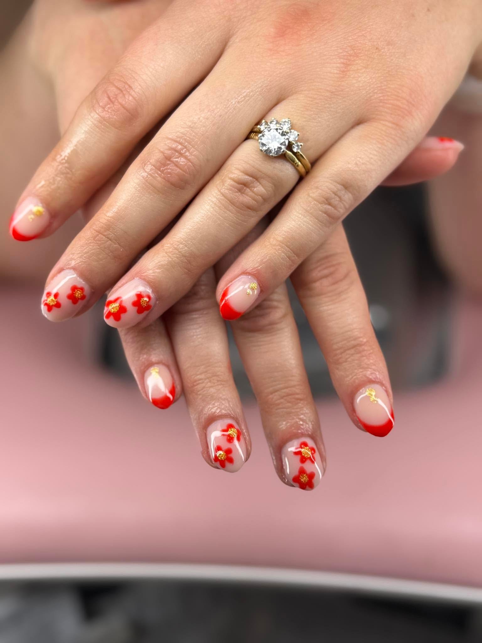 Nude nails with red flowers and gold accent details