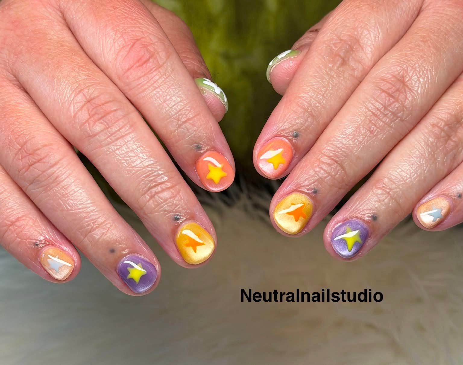 Pastel multicolor nails each with a hand-painted star