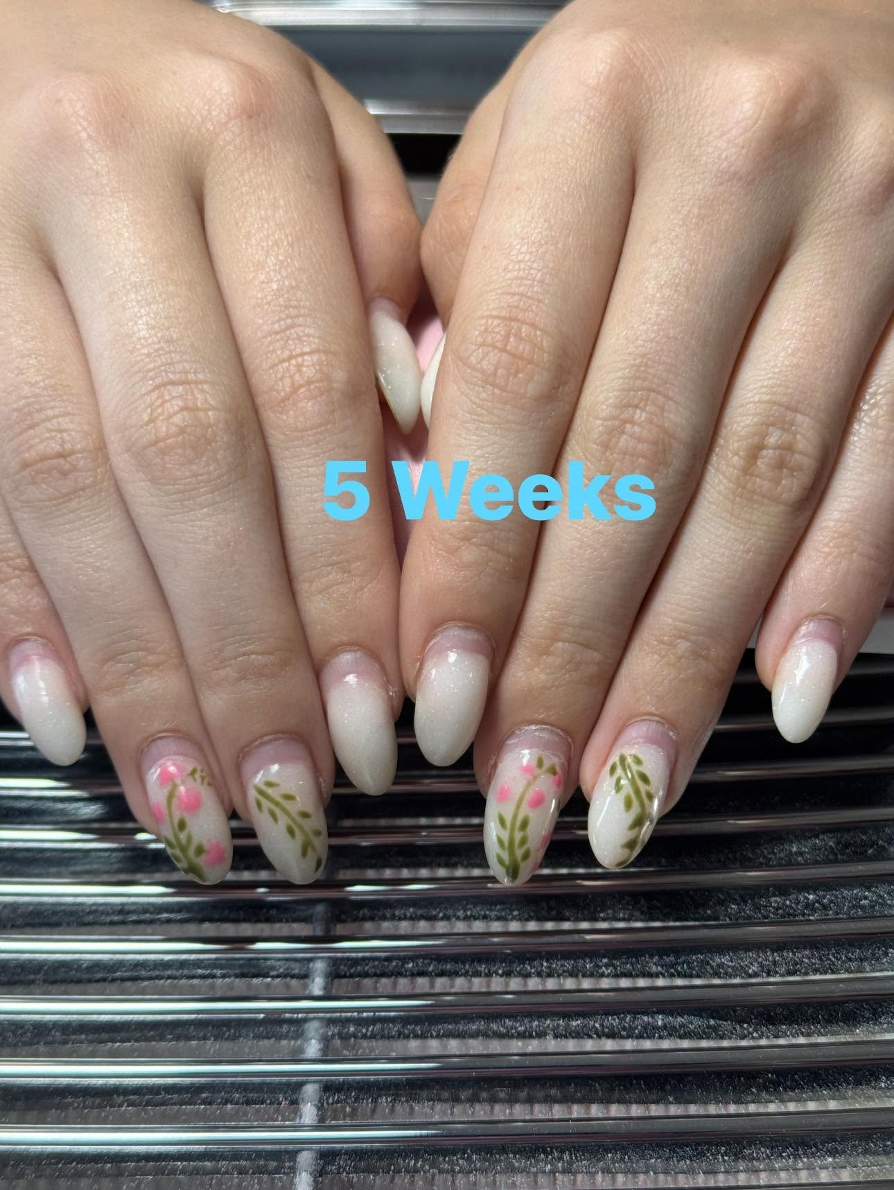 Cream nails with painted pink and green floral vines