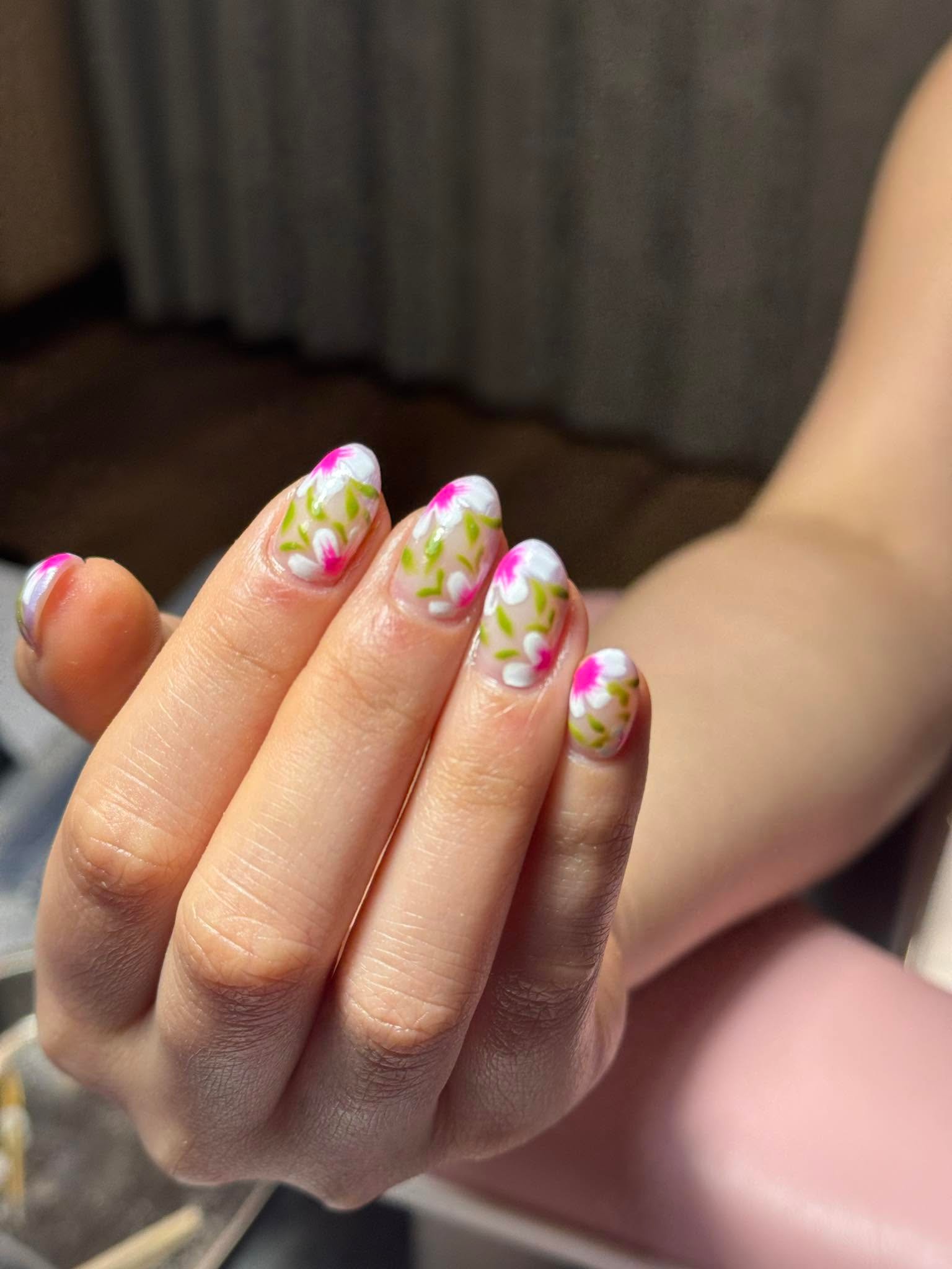 Hand-painted white and pink floral nail art on sheer base