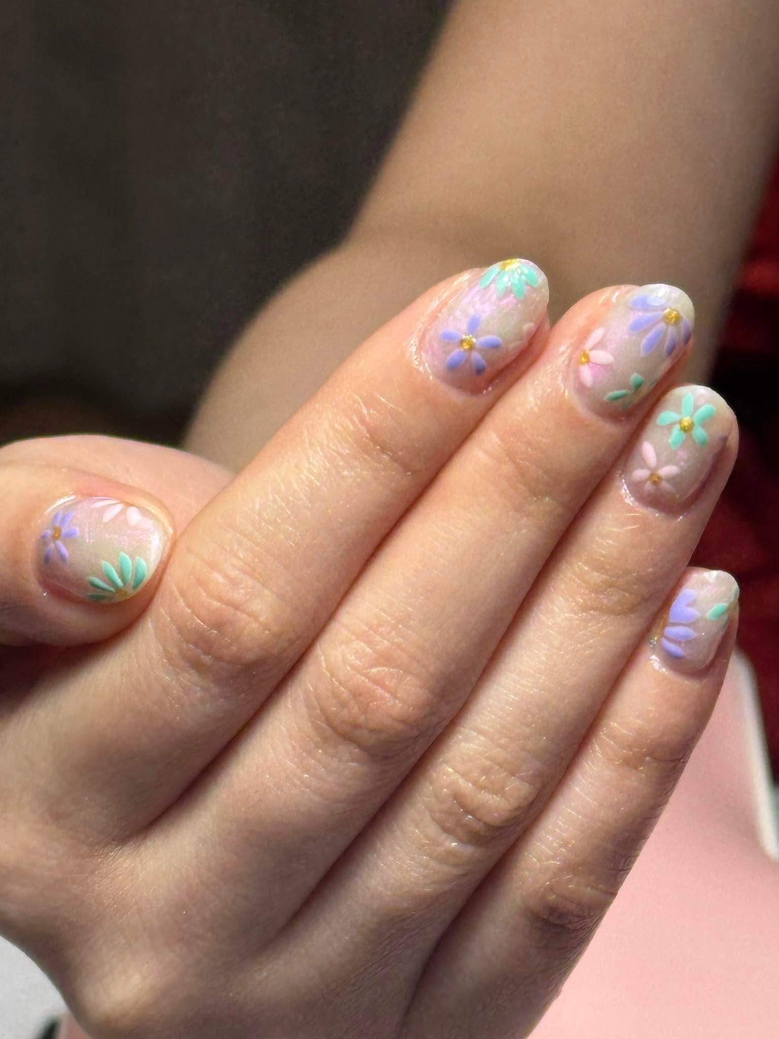 Iridescent nude nails with pastel daisy nail art in mint, lavender and pink