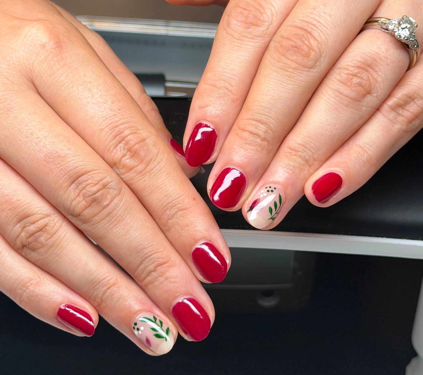 Burgundy red gel manicure with a green leaf accent nail