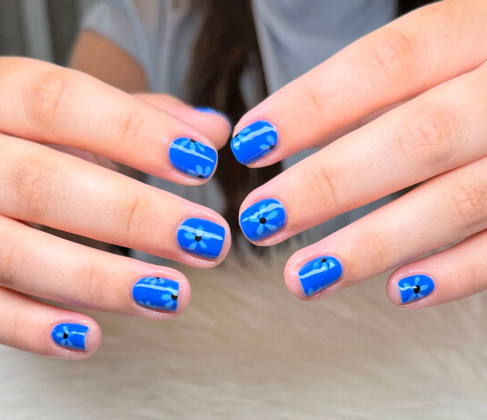 Cobalt blue manicure with white daisy design