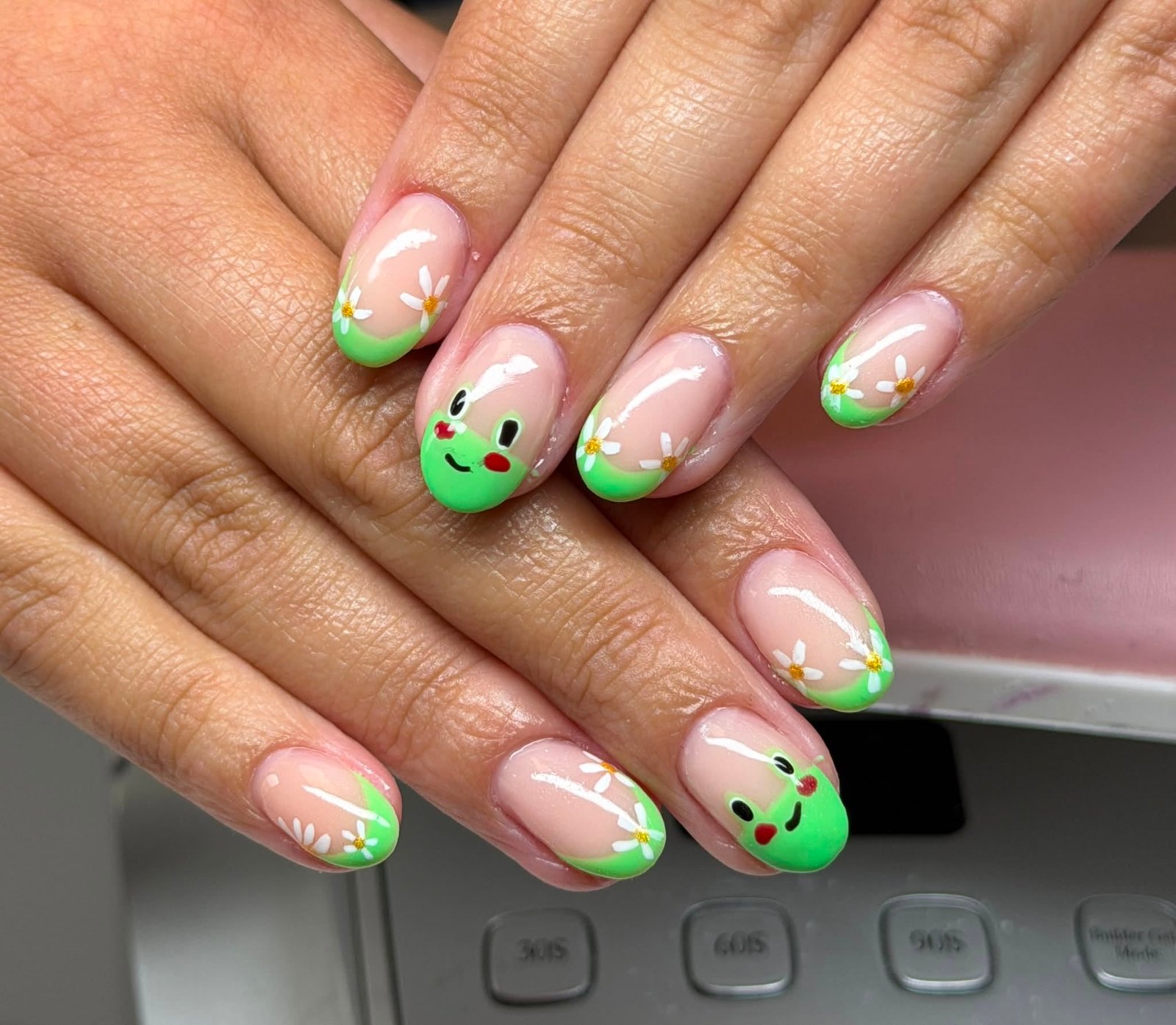 Green manicure with frog cartoon and daisy art