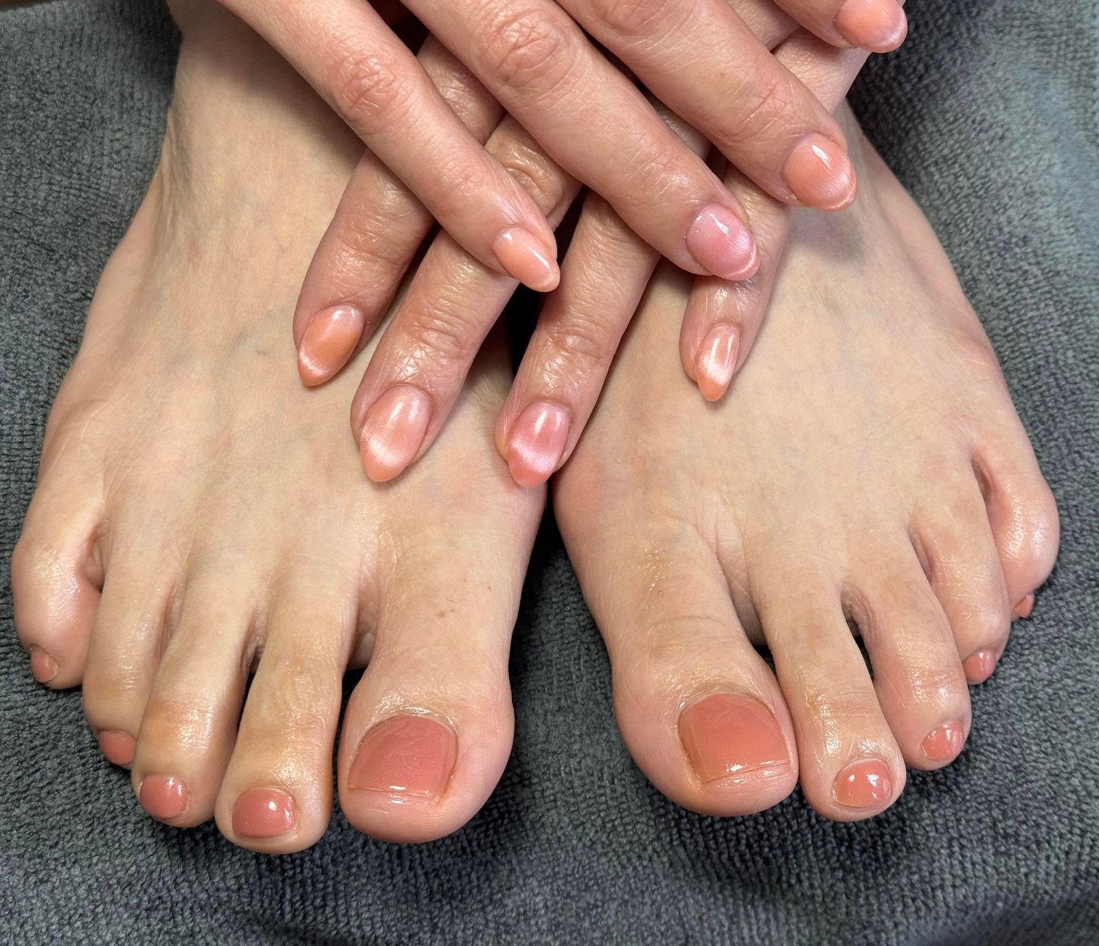 Matching nude shimmer manicure and pedicure on hands and feet