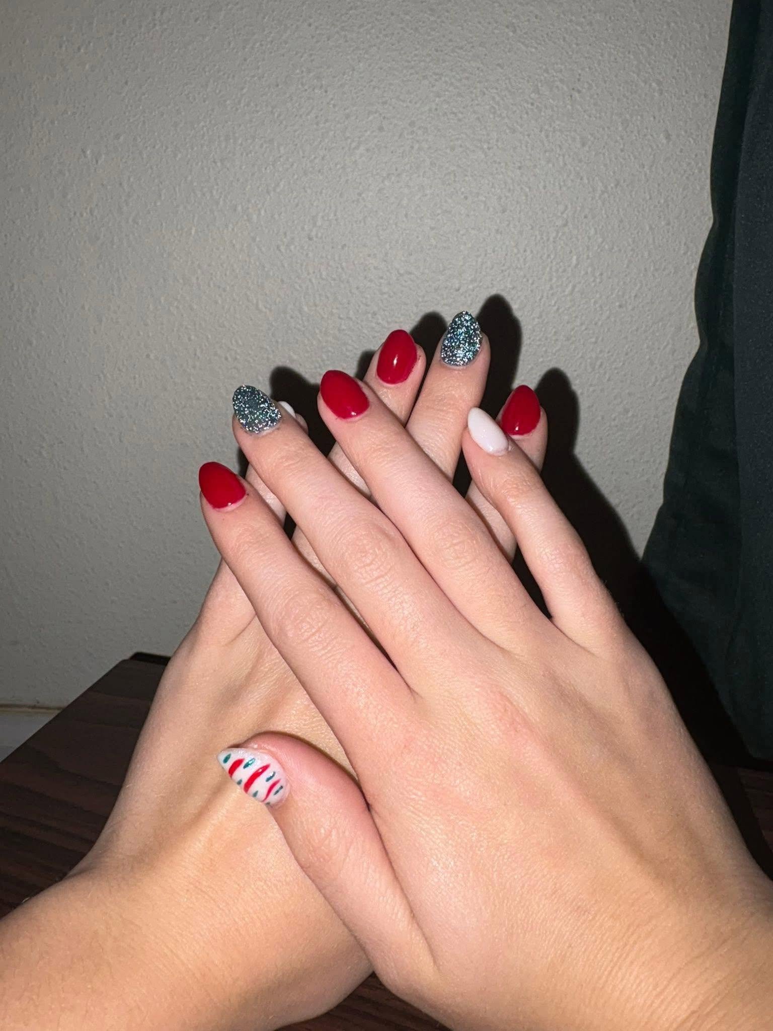 Red, white and glitter Christmas nails with candy-cane stripes